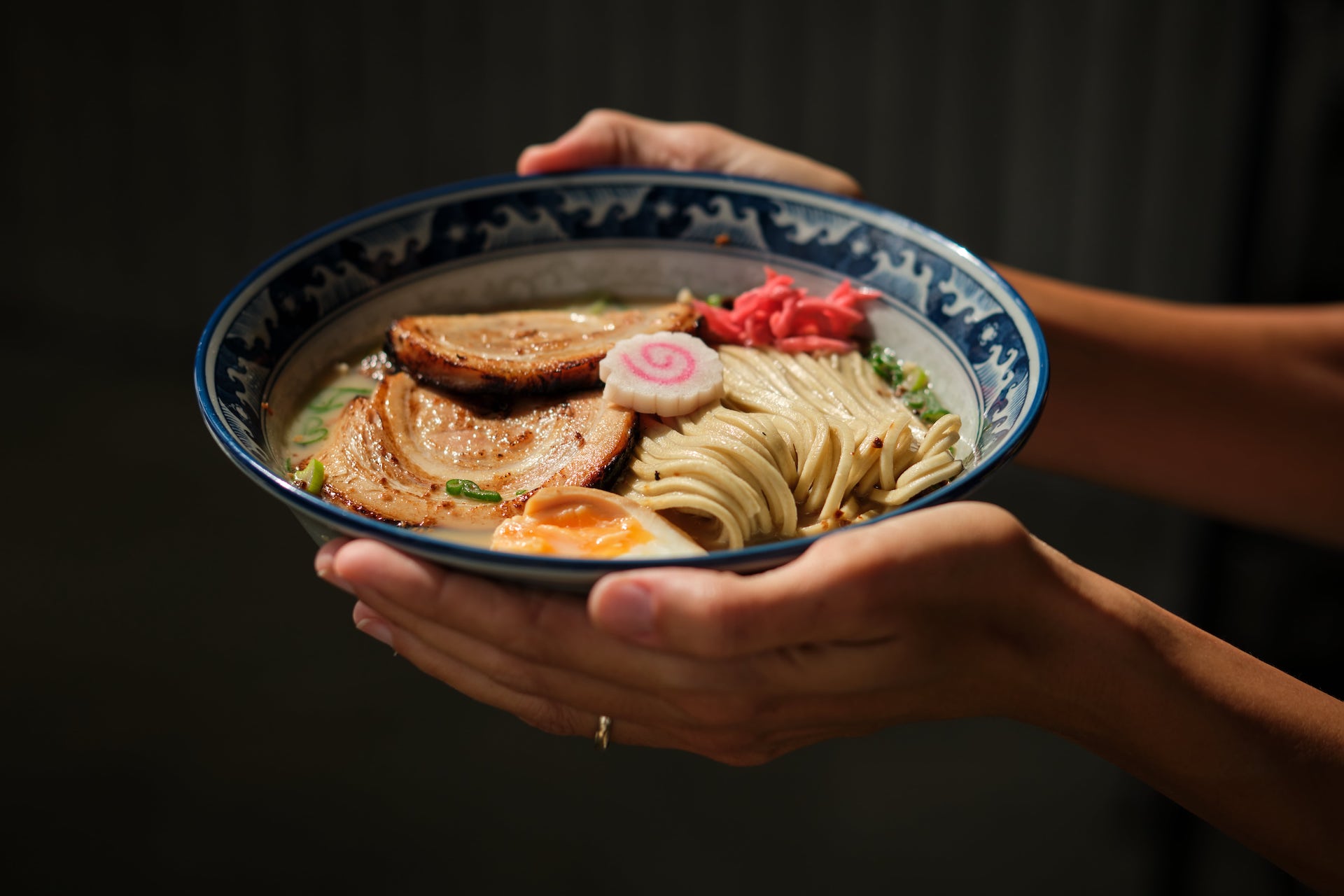 mani che stringono una ciotola di ramen