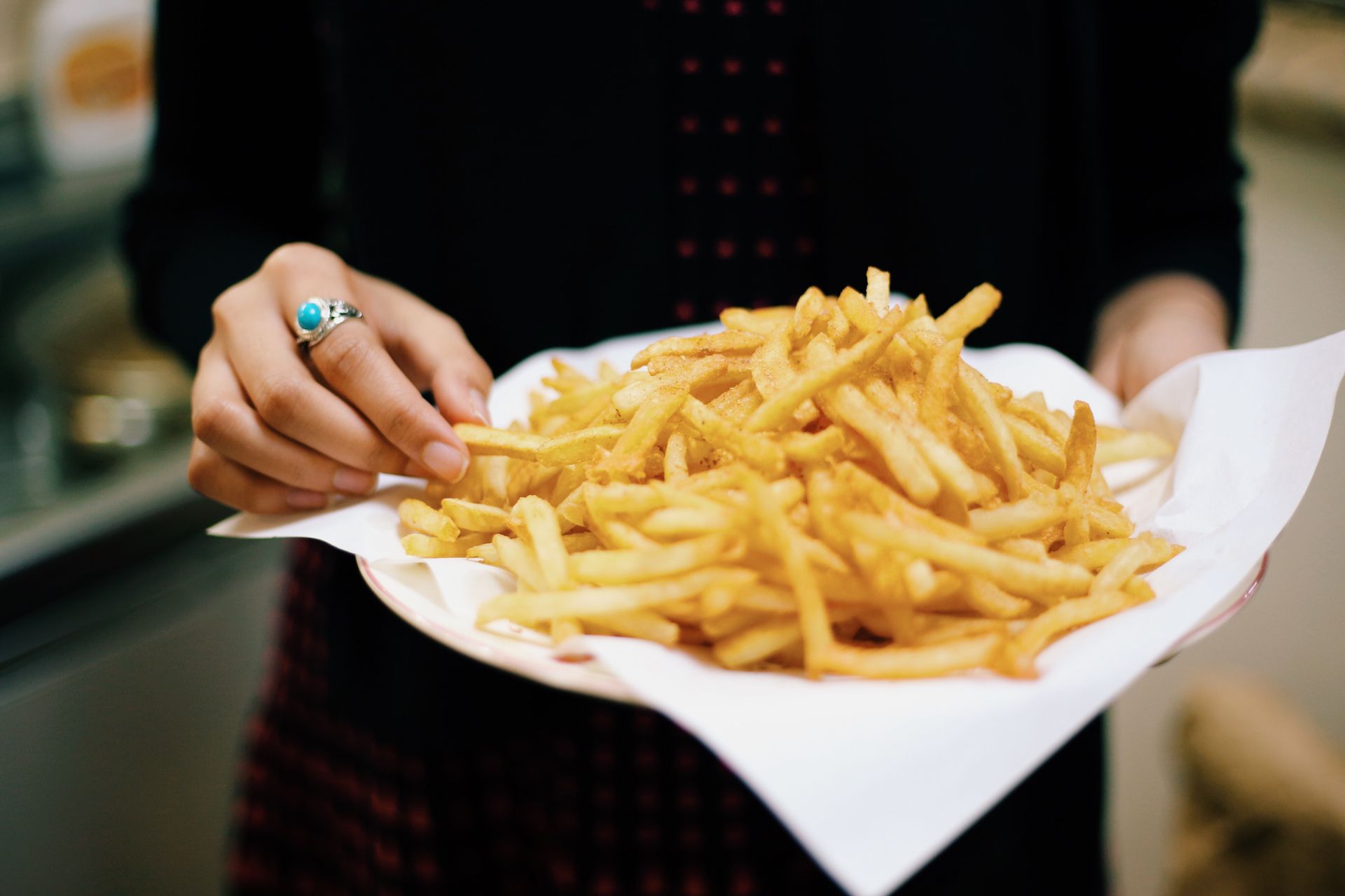 piatto di patatine fritte in mano a ragazza